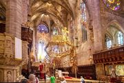 Blick auf die Apsis, die Empore und das Kreuz aus dem Seitenschiff der Kathedrale von Palma auf Mallorca.
